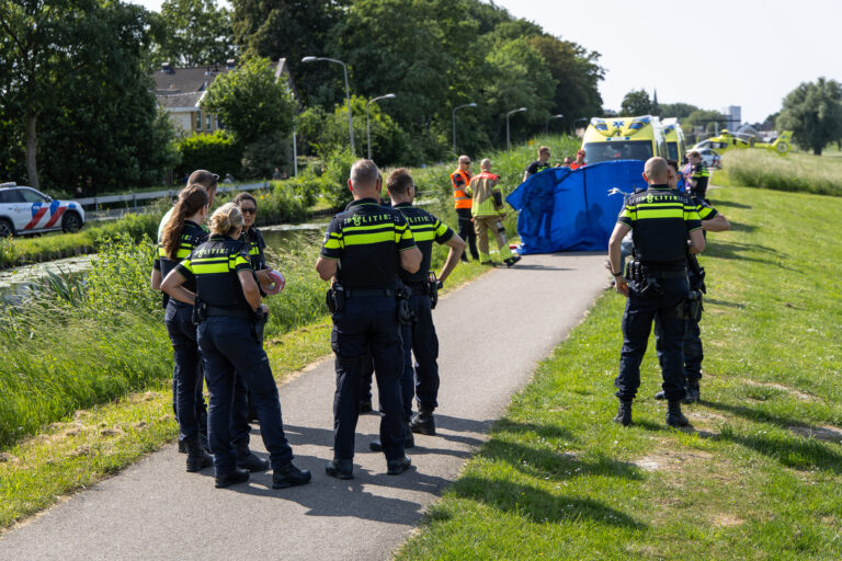 Hulpverleners staan op de Oostringdijk vanwege een persoon te water