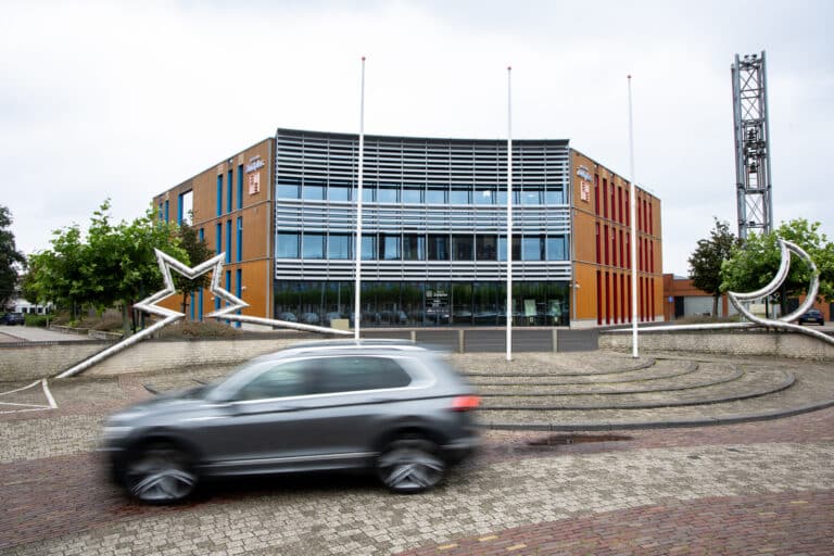 Een auto rijdt over het Raadhuisplein in Nieuwerkerk aan den IJssel
